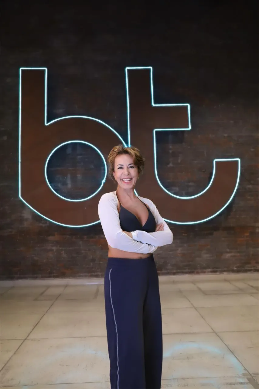 Regina diante do letreiro da Bodytech