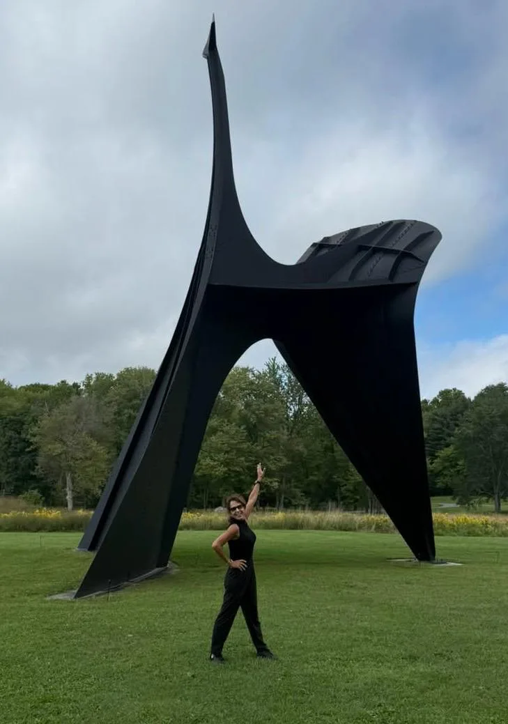 Regina dançando diante de uma escultura