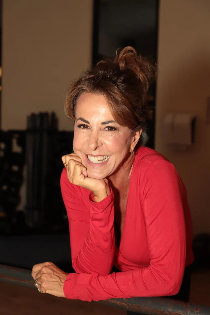 Regina Calil sorrindo, de blusa vermelha